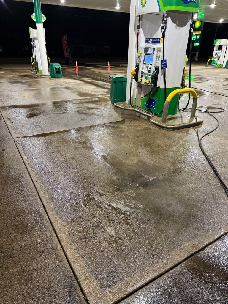 Green and white fuel pump at an empty gas station during evening hours